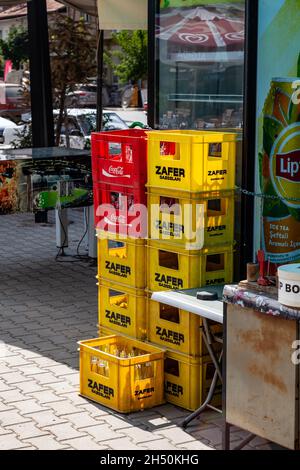 Esilova, Turchia - 08. 28. 2021: Scatole di plastica gialla e rossa di bevande di vetro all'esterno di un bar. Acqua, bibite analcoliche e birra con i marchi stampigliati o Foto Stock