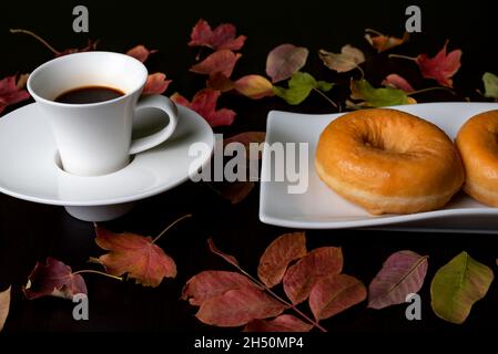 Tazza nera tazza nera con chicchi di caffè accanto ad essa su