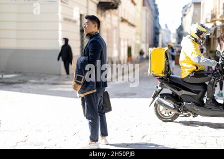 Uomo stare in piedi sulla strada della città e attendere qualcuno Foto Stock