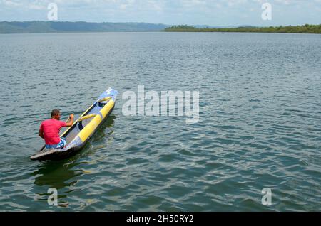 Cachoeira, Bahia, Brasile - 29 novembre 2014: Il pescatore che paddling la sua canoa di colore blu e giallo nel grande fiume Paraguacu, situato nel Brasile Foto Stock