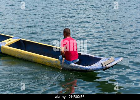 Cachoeira, Bahia, Brasile - 29 novembre 2014: Pescatore che naviga con la sua canoa blu e gialla sul grande fiume Paraguacu, situato nel Brasile Foto Stock