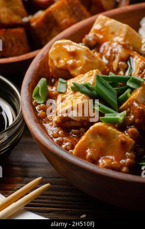 Piatto di tofu di Mapo di cagliata di soia che è tenuto in bacchette Foto Stock