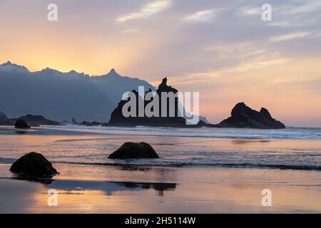 Splendido tramonto sulla spiaggia di Benijo o Playa de Benijo con maestose rocce vulcaniche che emergono dalla frana Atlantico e delineate dalla montagna di Anaga Foto Stock