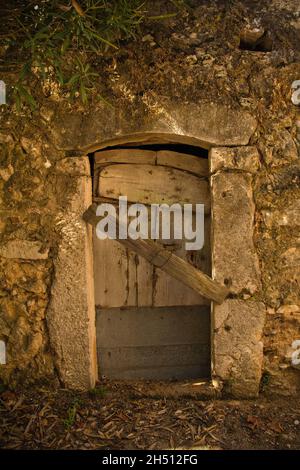 Un'antica porta di legno in un edificio in pietra nel villaggio storico di Dobrinj collina sull'isola di Krk nella contea di Primorje-Gorski Kotar, nella Croazia occidentale Foto Stock