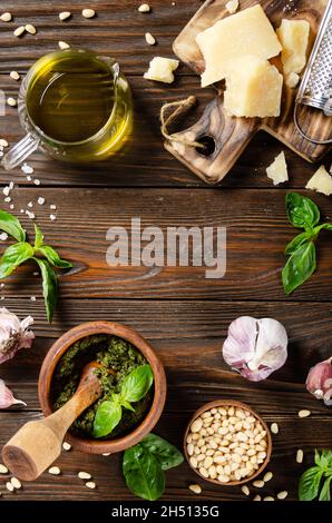 Fondo alimentare di pesto genovese in Malta di legno e i suoi ingredienti su tavola da cucina. Spazio per il testo Foto Stock