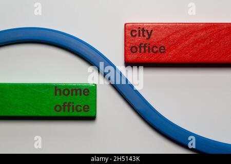 Un blocco verde sul quale è stato scritto il testo home Office. Diagonalmente di fronte a un blocco rosso con le parole ufficio città. Entrambi i blocchi sono separati da un bl Foto Stock