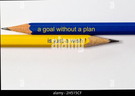 due matite affilate in punto blu e giallo in direzioni diverse isolate su sfondo bianco con la frase: un obiettivo senza un piano è j Foto Stock