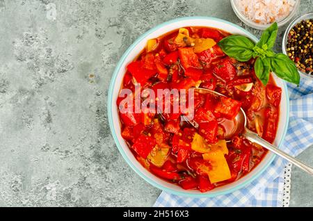 Piatto di verdure a base di peperoni dolci stufati e pomodori, lecho, menù vegetariano. Foto studio Foto Stock