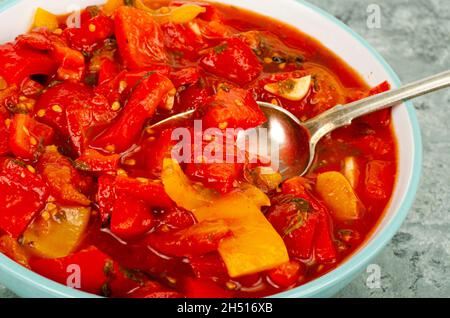 Piatto di verdure a base di peperoni dolci stufati e pomodori, lecho, menù vegetariano. Foto studio Foto Stock