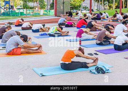 Miami Florida,Bayfront Park,classe stuoie yoga,gruppo cane stretching palestra uomini maschio donne outisde Foto Stock