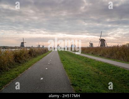 Pista ciclabile e sentiero attraverso i mulini a vento a Kinderdijk, Paesi Bassi Foto Stock