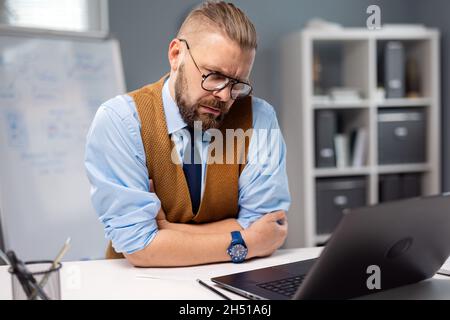 Imprenditore focalizzato tramite computer portatile Foto Stock