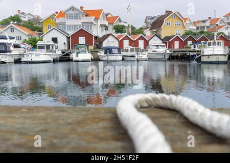Ockero, Svezia - 10 giugno 2021: Corda curva sfocata in primo piano con un tipico villaggio svedese sul mare Atlantico Foto Stock