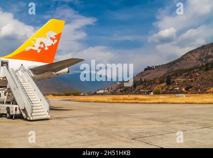 Paro/ Bhutan - 26 febbraio 2016: Coda e scala di Drukair - Royal Bhutan Airlines Airplane Airbus A319s a Paro Airport. Himalaya mountais e bhut Foto Stock