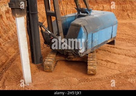 Macchina per la guida di cumuli. Macchina per la movimentazione di pelo con martello diesel in cantiere. Preparazione della fondazione del palo per la costruzione del Foto Stock