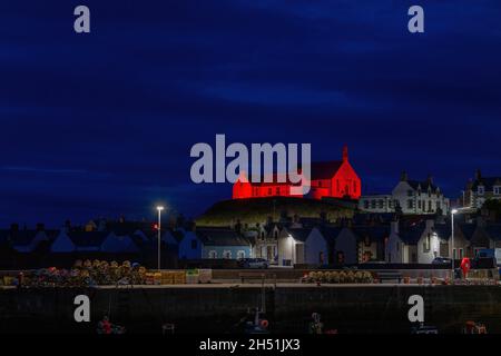 FINDOCHTY, MORAY, REGNO UNITO. 5 novembre 2021. Questa è la Chiesa che si affaccia sul porto e che si illuminava di rosso per Poppy Appeal Scotland a Findochty, Moray, Scozia, Regno Unito il 5 novembre 2021. Credit: JASPERIMAGE/Alamy Live News Foto Stock