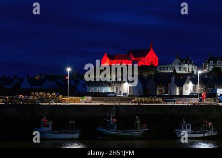 FINDOCHTY, MORAY, REGNO UNITO. 5 novembre 2021. Questa è la Chiesa che si affaccia sul porto e che si illuminava di rosso per Poppy Appeal Scotland a Findochty, Moray, Scozia, Regno Unito il 5 novembre 2021. Credit: JASPERIMAGE/Alamy Live News Foto Stock