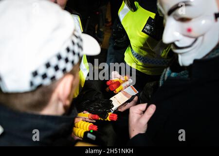 Londra, Regno Unito. 05 novembre 2021. La polizia sequestrano i fuochi d'artificio da una persona che stava partecipando all'annuale milione di Mask marzo attraverso la città. Il movimento Anonymous è solidale per una società emarginata dall'élite politica e dalle società associate. Credit: Andy Barton/Alamy Live News Foto Stock