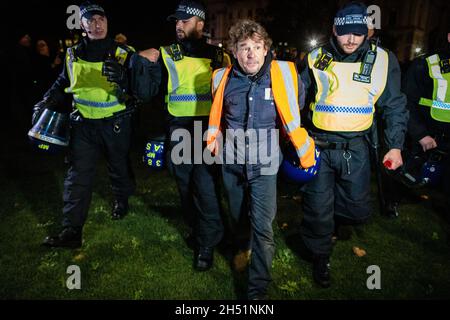 Londra, Regno Unito. 05 novembre 2021. Un manifestante viene arrestato dalla polizia e portato via durante l'annuale milione di Mask march attraverso la città. Il movimento Anonymous è solidale per una società emarginata dall'élite politica e dalle società associate. Credit: Andy Barton/Alamy Live News Foto Stock