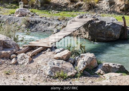 Mavzoley Rudaki, Provincia di Sughd, Tagikistan. Semplice ponte di legno sul fiume Urech. Foto Stock