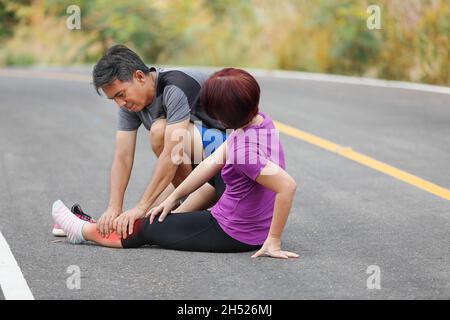 Femmina di mezza età con una cramp mentre jogging, massaggio vitello Foto Stock