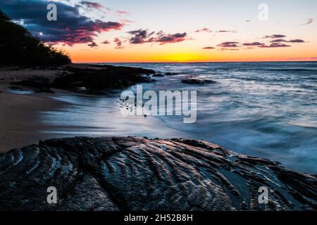 Onde che lavano sopra i flussi antichi di Lava sulla spiaggia di Kapalaoa al tramonto, Baia di Anaeho'omalu, Isola delle Hawaii, Hawaii, Stati Uniti Foto Stock