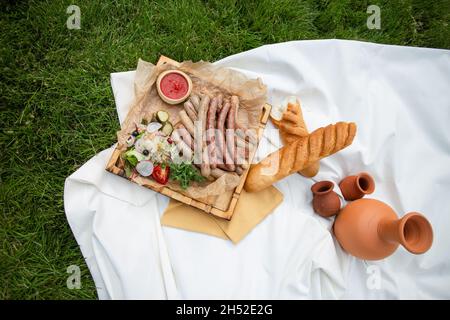 picnic. salsicce alla griglia fatte in casa con vista dall'alto del vino. Foto Stock