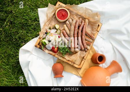 picnic. salsicce alla griglia fatte in casa con vista dall'alto del vino. Foto Stock