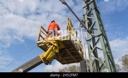 Montatori di linea catenaria che lavorano su un dispositivo di tensionamento Foto Stock