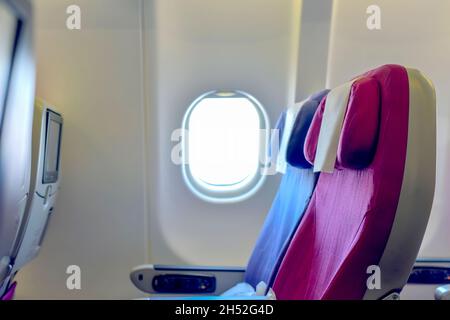 Sedile e finestrino della compagnia aerea. Sedili aerei passeggeri vuoti nella cabina. Foto Stock