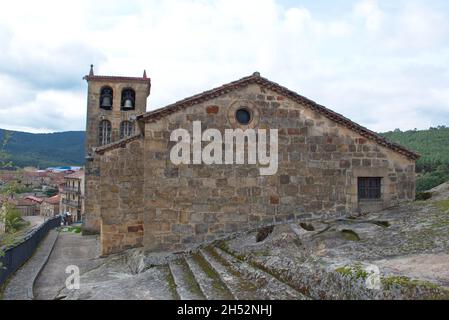 Vista posteriore della Chiesa di San Adriano Martir nel villaggio di Regumiel de la Sierra, provincia di Burgos, Spagna. Sotto di esso sono tombe antropomorfe da Foto Stock