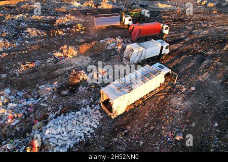 Smaltimento rifiuti in discarica. Discarica di rifiuti con rifiuti di plastica e polietilene. Il veicolo per la raccolta rifiuti scarica rifiuti in discarica. Ridurre le emissioni di gas serra Foto Stock