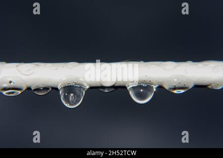 In una giornata piovosa, è possibile appendere gocce d'acqua dal cavo elettrico Foto Stock