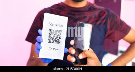 Primo piano non riconoscibile del cliente che effettua il pagamento utilizzando il codice QR nello smartphone per barbarare - concetto di pagamento e o Digital pay, Cashless Foto Stock