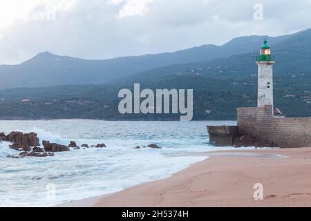 Torre faro con la parte superiore verde e la luce accesa. Estate sera paesaggio di Propriano, Corsica isola, Francia Foto Stock