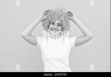 guarda quello che ho. festa di compleanno goer. felice donna divertente in parrucca ricurly e corona. Foto Stock