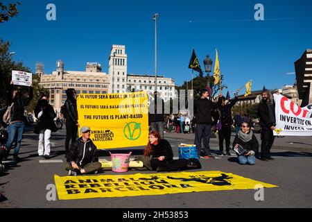 Spagna. 6 novembre 2021. Le persone del gruppo della ribellione animale detengono striscioni e cartelli mentre organizzano un'azione contro l'incontro COP26 in Piazza Catalunya a Barcellona, in Spagna, il 6 novembre 2021. La ribellione animale è un collettivo ambientalista e per i diritti degli animali che sostiene il passaggio a una dieta basata sulle piante e la fine della crudeltà degli animali. (Foto di Davide Bonaldo/Sipa USA) Credit: Sipa USA/Alamy Live News Foto Stock