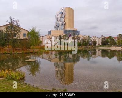 La torre Luma di Frank Gehry si riflette nello stagno al Parc des ateliers, Arles, Francia Foto Stock