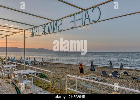 Uno snack bar senza turisti con vista sulla spiaggia e l'azzurro Mar Mediterraneo, Creta, Grecia, 11 ottobre 2021 Foto Stock