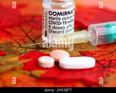 Comirrnaty Biontech Pfizer fiala di vaccinazione con una siringa contro il virus covid-19 o Corona su foglietti rossi Foto Stock