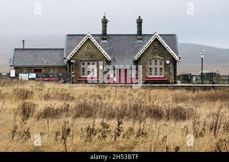 Una giornata d'autunno nebbiosa, la stazione di Ribblehead sulla linea ferroviaria Settle-Carlisle. Foto Stock