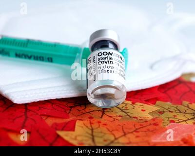 Comirrnaty Biontech Pfizer fiala di vaccinazione con una siringa contro il virus covid-19 o Corona su foglietti rossi Foto Stock