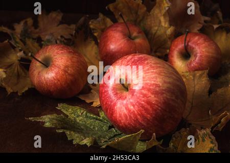 mele alla rinfusa su sfondo di legno scuro in stile rustico Foto Stock