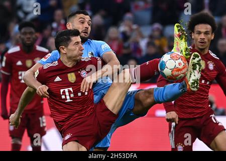 Monaco di Baviera, Germania. 6 novembre 2021. Calcio: Bundesliga, Bayern Monaco di Baviera - SC Friburgo, Matchday 11 - Allianz Arena: Robert Lewandowski di Monaco (fronte) combatte per la palla con Manuel Gulde di Friburgo, Leroy Sane di Monaco sulla destra. Credit: Sven Hoppe/dpa/Alamy Live News Foto Stock