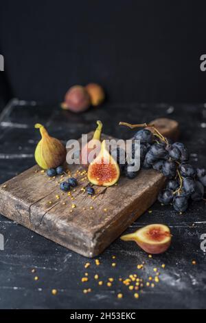 Uva matura e fichi su tavola di legno scuro Foto Stock