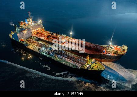 Due petroliere di notte, si trovano nelle vicinanze in un ghiaccio giovane. Riprese dall'aria. Foto Stock