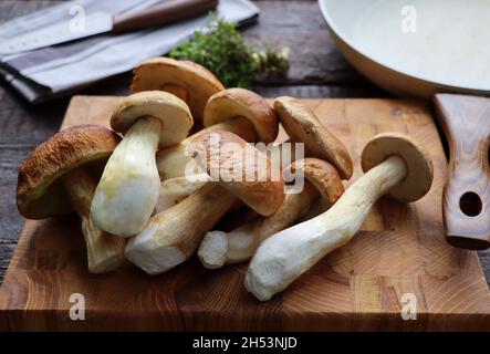 Funghi boleto su sfondo di legno. Funghi del cep autunnali. Raccolta e cottura di funghi Foto Stock