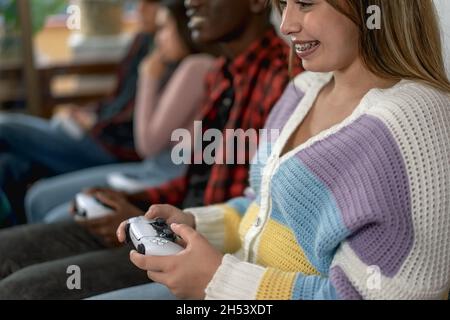 Giovani adolescenti multirazziali che giocano a console di videogiochi online a casa - giovani dipendenti di nuove tecnologie di intrattenimento Foto Stock