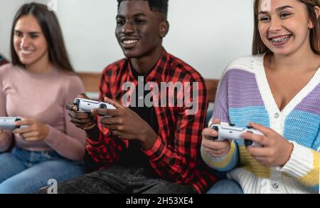 Giovani adolescenti multirazziali che giocano a console di videogiochi online a casa - giovani dipendenti di nuove tecnologie di intrattenimento Foto Stock