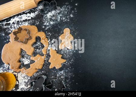 Le mani dei bambini fanno i biscotti del pan di zenzero di Capodanno su un tavolo di legno. Capodanno e Natale. Foto Stock